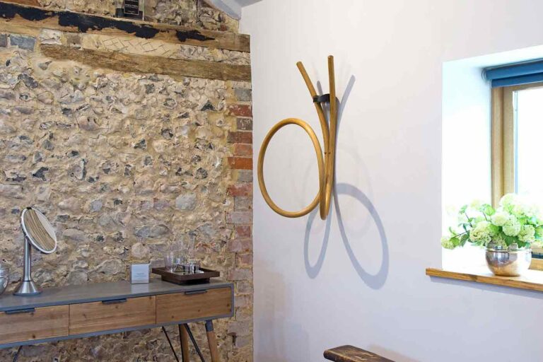 Curved and flowing clothes valet on wall